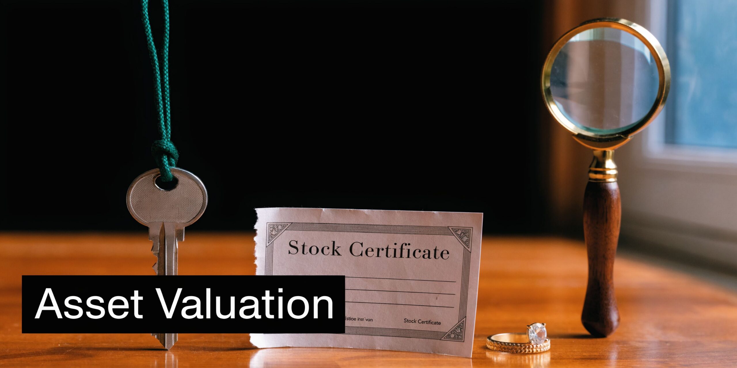 A stock certificate, a key, and a diamond ring on a table with a magnifying glass.