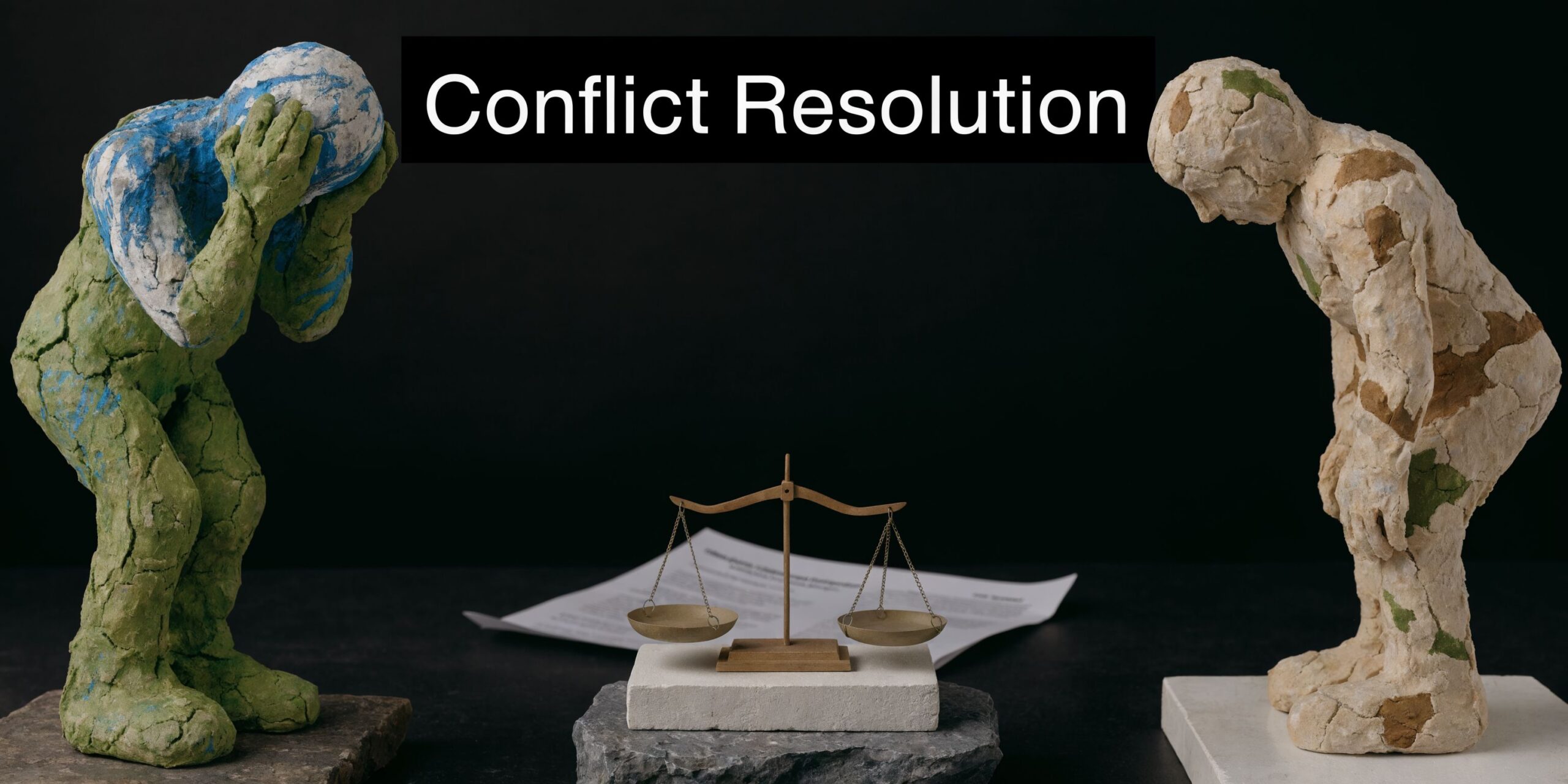 A miniature scale of justice sits between two abstract clay figures representing conflict and resolution.
