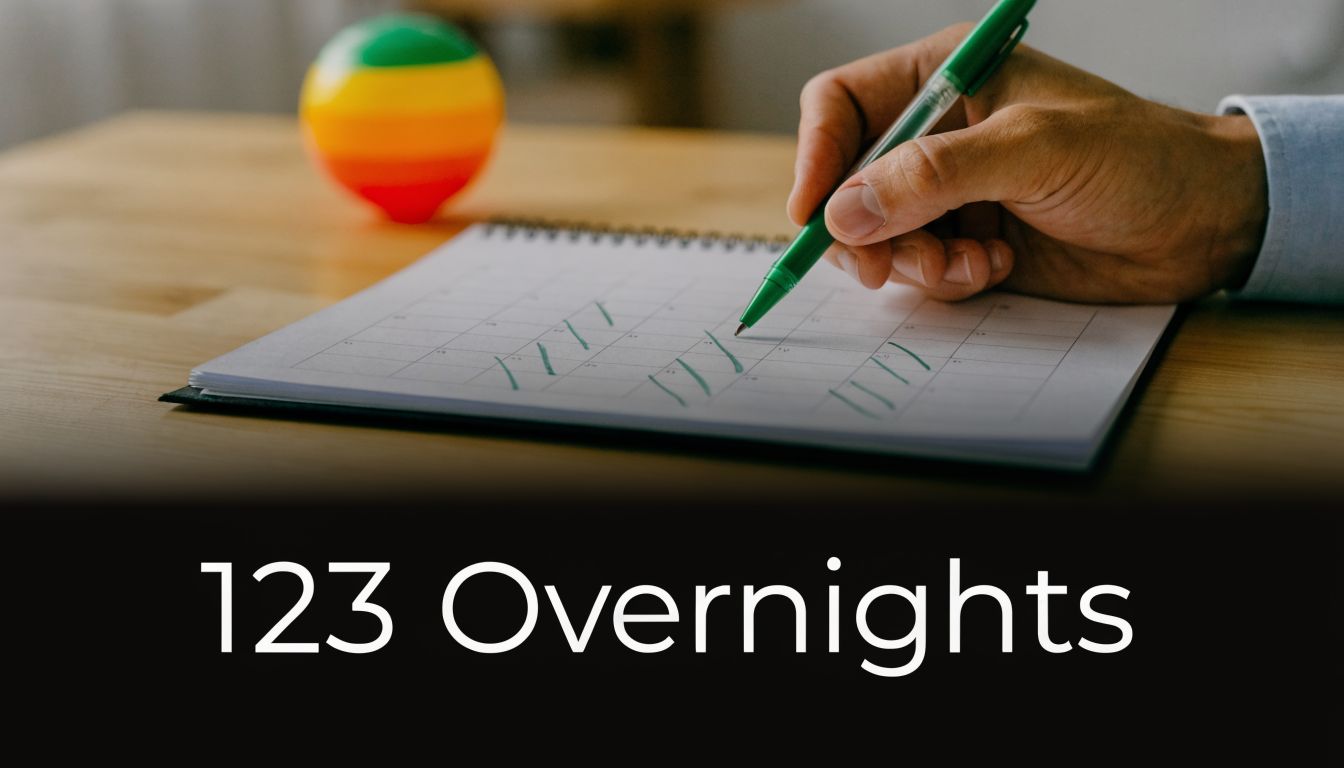 A person marks a calendar with a green pen to track overnight visits for parenting time arrangements.