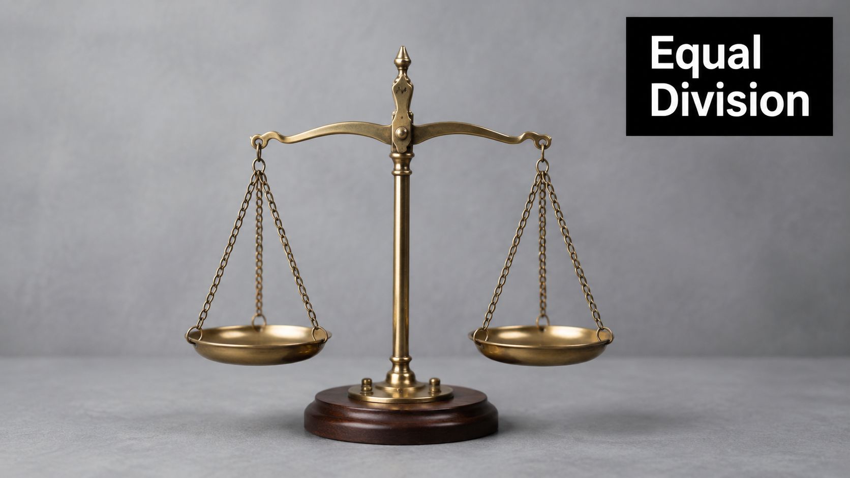 A golden scales of justice balance on a wooden base against a plain grey background.